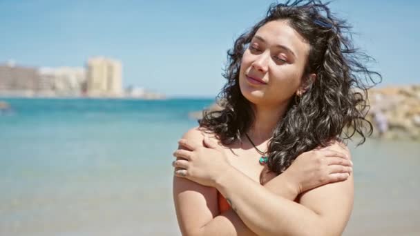 年轻美丽的惊慌失措的女游客穿着比基尼在海滩上拥抱自己 — 图库视频影像