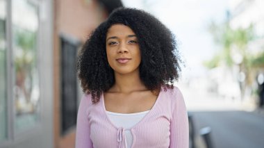Sokakta ciddi bir ifadeyle duran Afrikalı Amerikalı kadın.