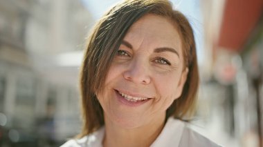 Middle age hispanic woman smiling confident at street