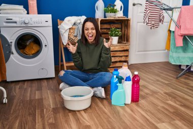 Elle çamaşır yıkayan genç İspanyol kadın başarının çılgınlığını ve çılgınlığını kollarını kaldırmış ve gözlerini kapatmış heyecanla bağırarak kutluyor. Kazanan konsept 