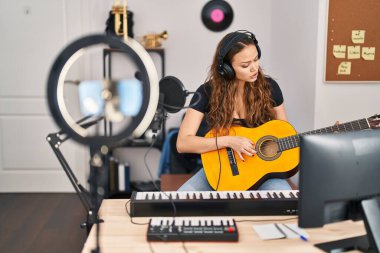 Güzel İspanyol kadın müzisyen müzik stüdyosunda klasik gitar dersi alıyor.