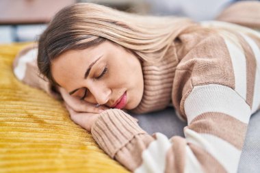 Young woman lying on sofa sleeping at home
