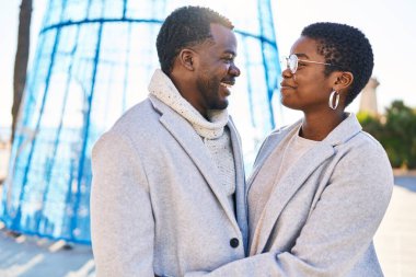 Man and woman couple hugging each other standing at street