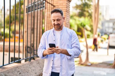 Young caucasian man smiling confident using smartphone at street