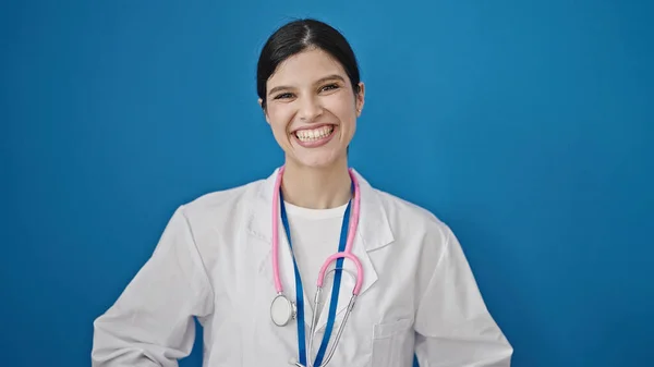 年轻美丽的惊慌失措的女医生面带微笑 自信地站在孤独的蓝色背景之上 — 图库照片
