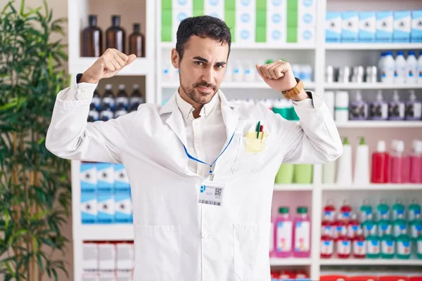 Homem Hispânico Bonito Trabalhando Farmácia Farmácia Mostrando Músculos Braços Sorrindo — Fotografia de Stock