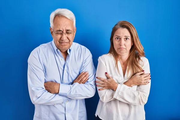 Medelåldern Latinamerikanskt Par Står Över Blå Bakgrund Skakar Och Fryser — Stockfoto