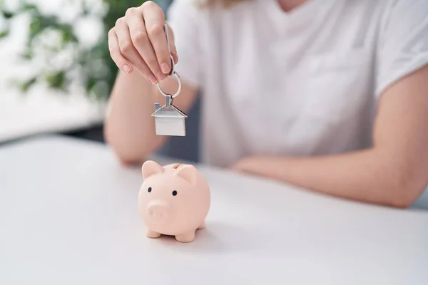 Young Woman Inserting House Key Piggy Bank Home — Stock fotografie
