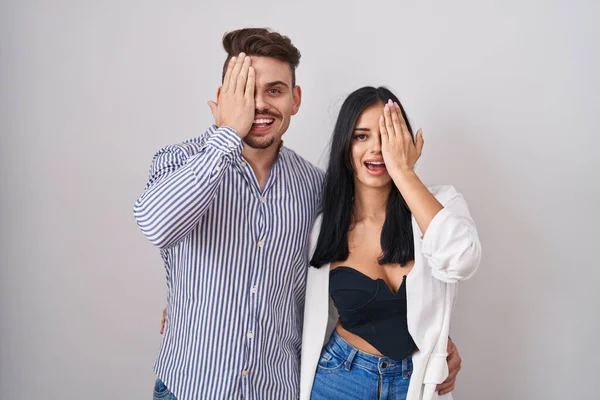 Junges Hispanisches Paar Vor Weißem Hintergrund Das Ein Auge Mit — Stockfoto