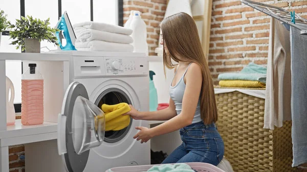 若い美しい女の子洗濯室で服を洗う — ストック写真