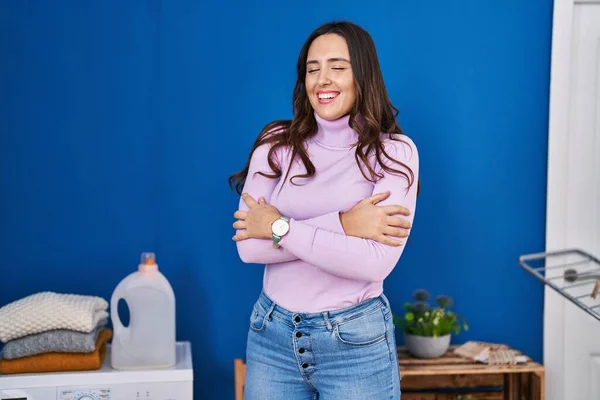 Young Hispanic Woman Smiling Confident Hugging Himself Laundry Room — Stockfoto