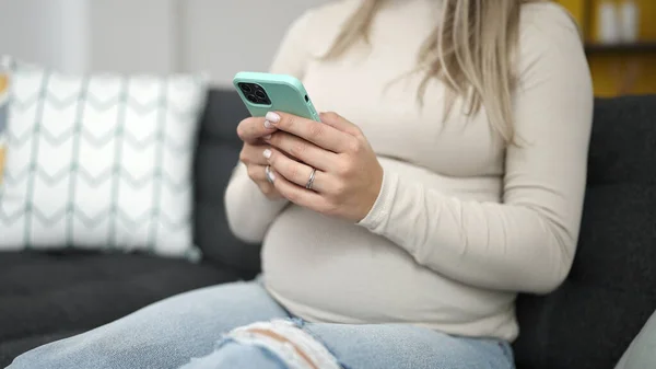 Jonge Zwangere Vrouw Met Smartphone Zittend Bank Thuis — Stockfoto