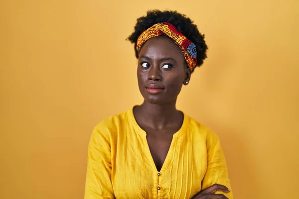 アフリカのターバンを身に着けているアフリカの若い女性は横を見て笑って — ストック写真