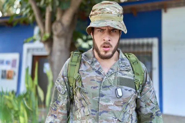 Young Hispanic Man Wearing Camouflage Army Uniform Outdoors Scared Amazed — Stock Photo, Image