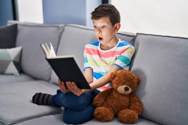 Niño Caucásico Joven Sentado Sofá Leyendo Libro Asustado Sorprendido Con —  Fotos de Stock
