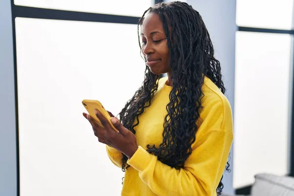 非洲裔美国女人在家里用智能手机充满自信地微笑 — 图库照片