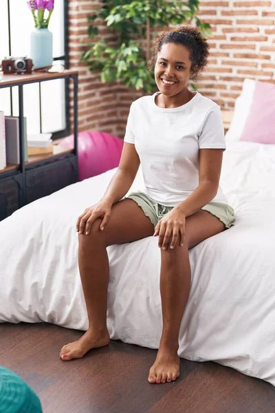 Afroamerykanka Uśmiecha Się Pewnie Siedząc Łóżku Sypialni — Zdjęcie stockowe