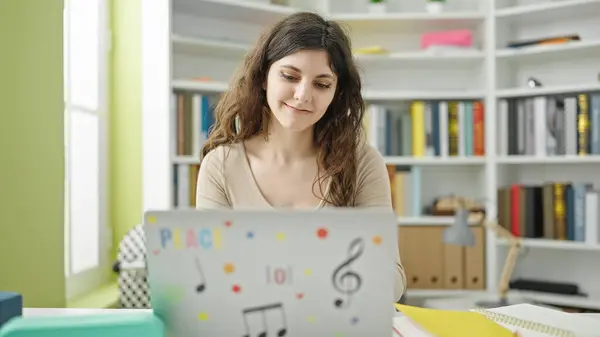 在图书馆大学 年轻美丽的惊慌失措的女学生用笔记本电脑充满自信地微笑 — 图库照片
