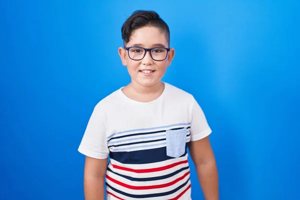 Joven Niño Hispano Pie Sobre Fondo Azul Con Una Sonrisa — Foto de Stock