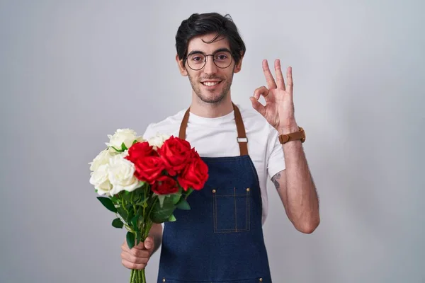 Joven Hombre Hispano Sosteniendo Ramo Rosas Blancas Rojas Sonriendo Positiva —  Fotos de Stock