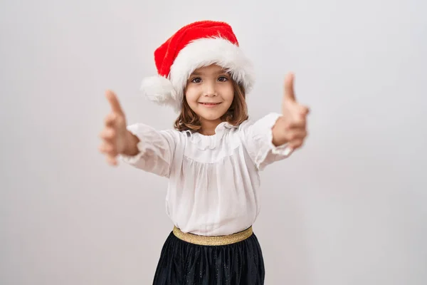 Malá Hispánka Vánočním Kloboukem Dívá Kamery Usmívá Otevřenou Náručí Aby — Stock fotografie