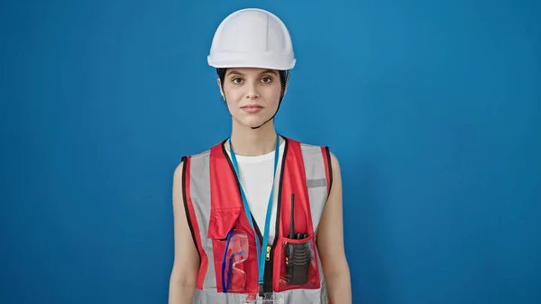 惊慌失措的女建筑工人 站在孤立的蓝色背景下 表情轻松 — 图库照片