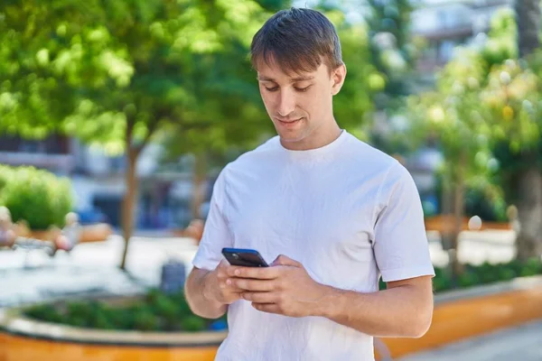 Jovem Caucasiano Homem Usando Smartphone Com Expressão Séria Parque — Fotografia de Stock