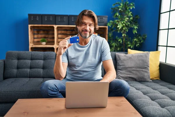 Homem Meia Idade Usando Laptop Cartão Crédito Sentado Sofá Casa — Fotografia de Stock