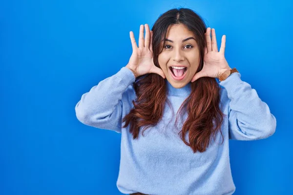 Hispanic Young Woman Standing Blue Background Smiling Cheerful Playing Peek — Stockfoto