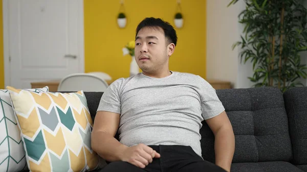 Young Chinese Man Sitting Sofa Serious Expression Home — Stock Photo, Image