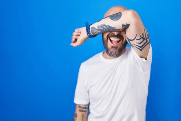 Hispanic Man Tattoos Standing Blue Background Covering Eyes Arm Smiling — Stock Photo, Image