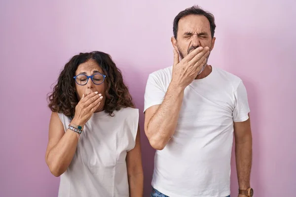 Middelbare Leeftijd Spaanse Paar Samen Roze Achtergrond Verveelde Gapen Moe — Stockfoto