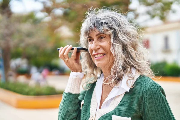 Frau Mittleren Alters Lächelt Selbstbewusst Und Hört Audiobotschaft Vom Smartphone — Stockfoto