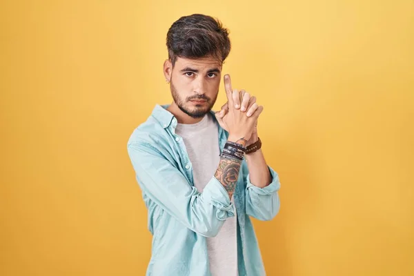 Joven Hombre Hispano Con Tatuajes Pie Sobre Fondo Amarillo Sosteniendo —  Fotos de Stock