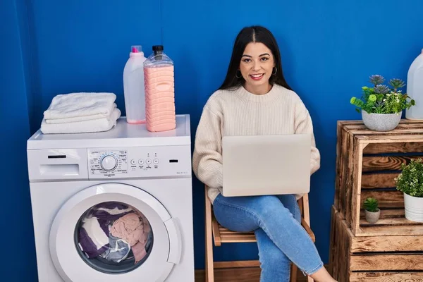 Young Beautiful Hispanic Woman Using Laptop Waiting Washing Machine Laundry — 图库照片