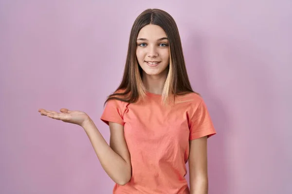 Девочка Подросток Стоящая Розовом Фоне Весело Улыбаясь Показывая Ладонью Камеру — стоковое фото