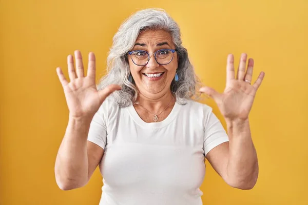 Sarı Arka Planda Gri Saçlı Orta Yaşlı Bir Kadın Numaralı — Stok fotoğraf