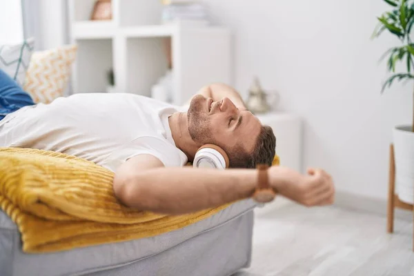 Young Caucasian Man Listening Music Lying Sofa Home — Foto de Stock