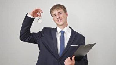 Kafkasyalı genç bir emlakçı elinde yeni evin anahtarları ve izole edilmiş beyaz arka planla kontrat tutuyor.