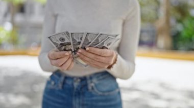 Parkta dolar sayan genç sarışın kadın.
