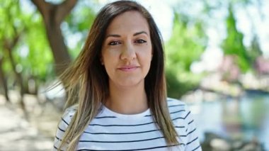 Ortadoğulu kadın parkta kendinden emin gülümsüyor.