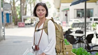 Genç ve güzel İspanyol kadın turist gülümsüyor. Kentin haritasını kahve dükkanının terasında tutuyor.