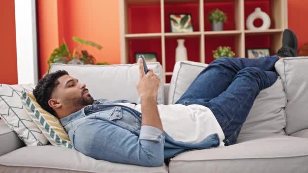 Uomo Afroamericano Utilizzando Smartphone Sdraiato Sul Divano Casa — Video Stock