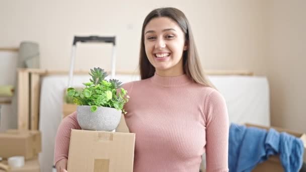 Joven Hermosa Mujer Hispana Sonriendo Confiado Sosteniendo Paquete Planta Nuevo — Vídeos de Stock