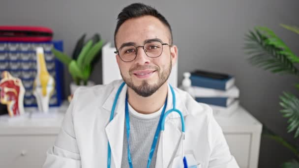 西班牙男人医生微笑着在诊所手拉手做心脏动作 — 图库视频影像