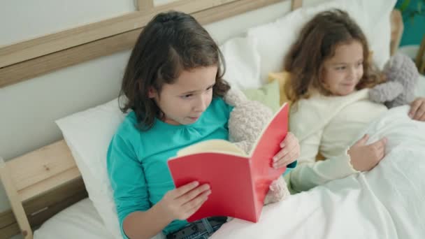 Adorable Niñas Leyendo Libro Acostado Cama Dormitorio — Vídeo de stock
