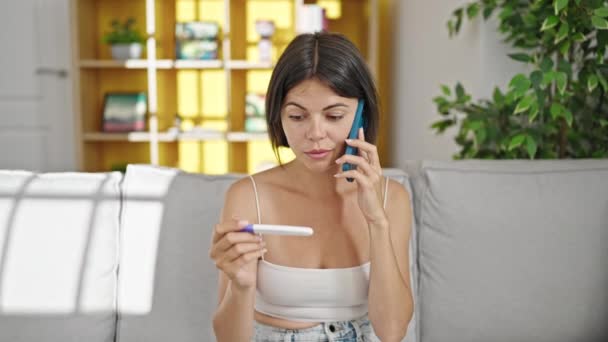 Νεαρή Όμορφη Ισπανόφωνη Γυναίκα Μιλάει Στο Smartphone Κρατώντας Τεστ Εγκυμοσύνης — Αρχείο Βίντεο