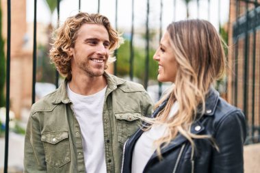 Erkek ve kadın bir arada durarak gülümsüyor.