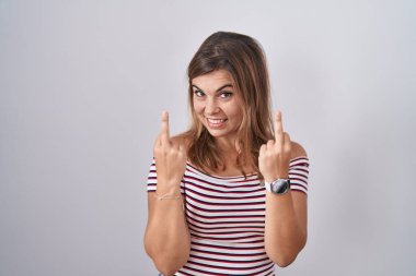 Young hispanic woman standing over isolated background showing middle finger doing fuck you bad expression, provocation and rude attitude. screaming excited 