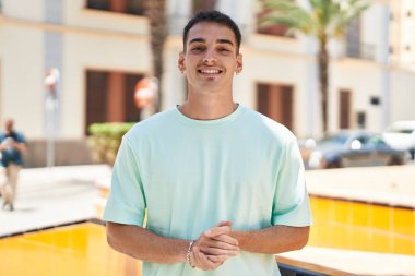 Sokakta kendinden emin gülümseyen İspanyol genç adam.